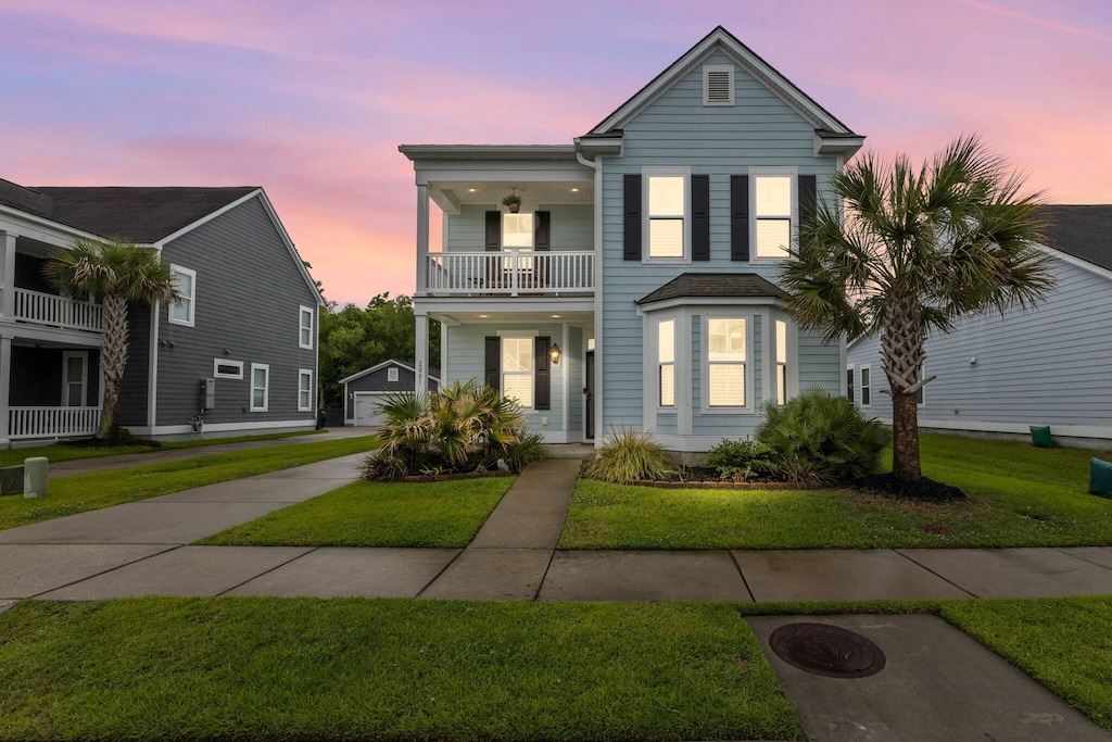 2881 Rutherford Way, Charleston, SC 29414 - view of front facade featuring a balcony, an outbuilding, a yard, a detached garage, and concrete driveway