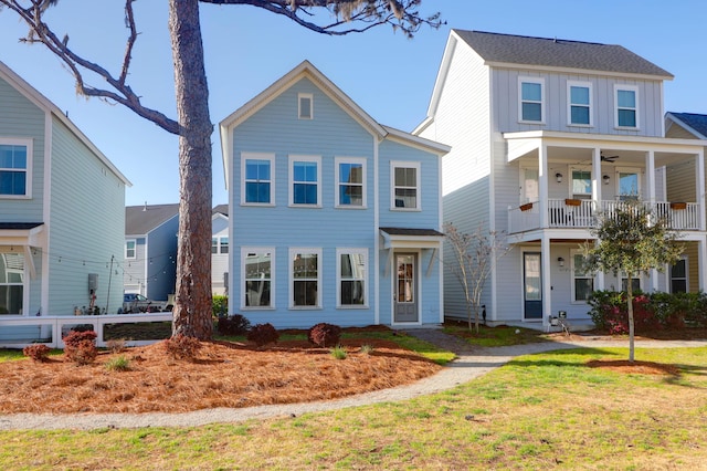 view of front of house featuring a front yard, board and batten siding, and ceiling fan