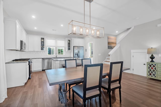 dining area with recessed lighting, stairway, and wood finished floors