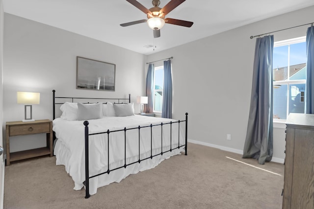 bedroom featuring multiple windows, carpet floors, baseboards, and a ceiling fan