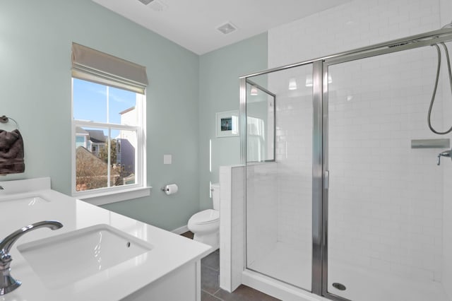 bathroom featuring double vanity, a stall shower, and a sink