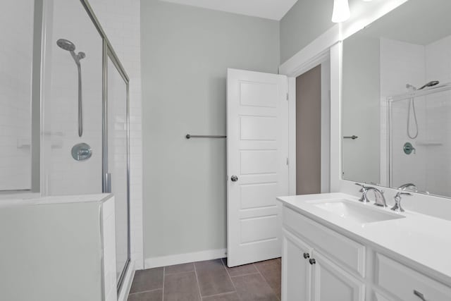 full bathroom featuring a stall shower, vanity, and baseboards