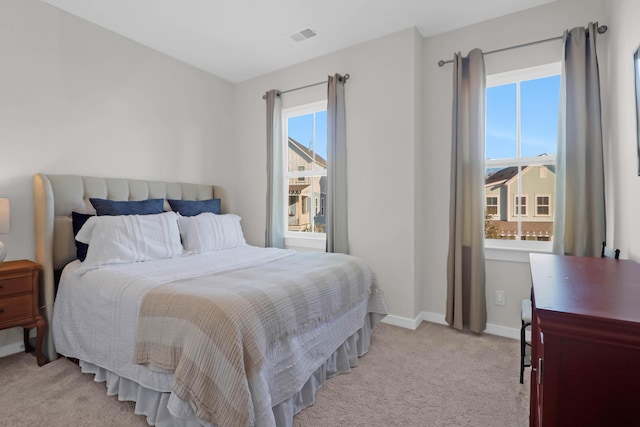 bedroom featuring light carpet and baseboards