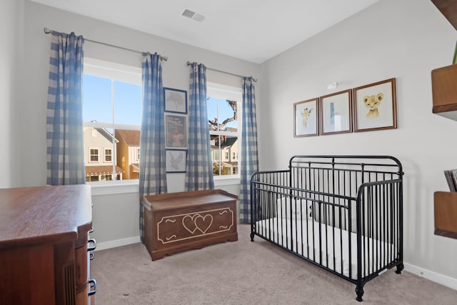 carpeted bedroom with visible vents, a nursery area, and baseboards