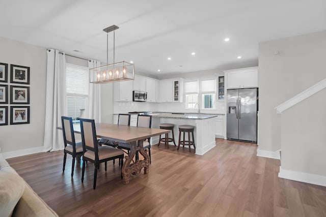 dining space with recessed lighting, wood finished floors, and baseboards