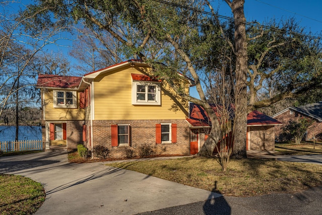 view of front of house featuring concrete driveway, brick siding, and a front lawn