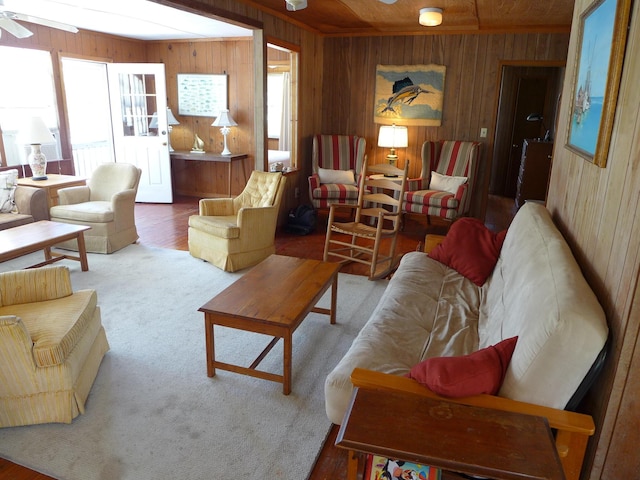 living room with wooden walls, ceiling fan, and a healthy amount of sunlight