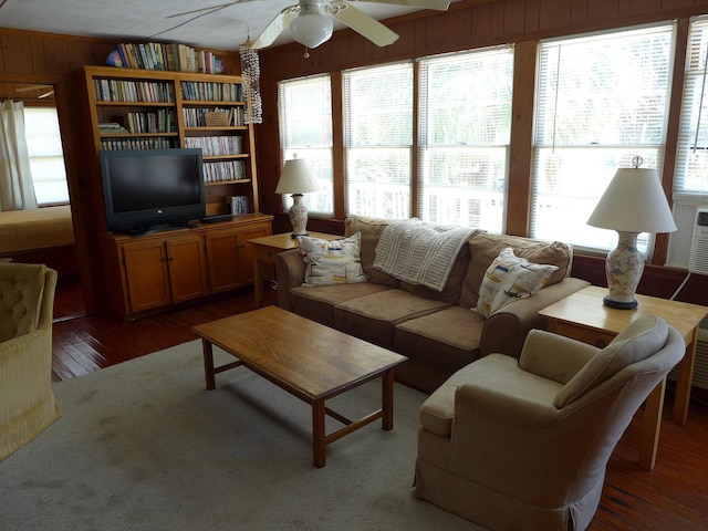 living room featuring wooden walls, a ceiling fan, and hardwood / wood-style floors