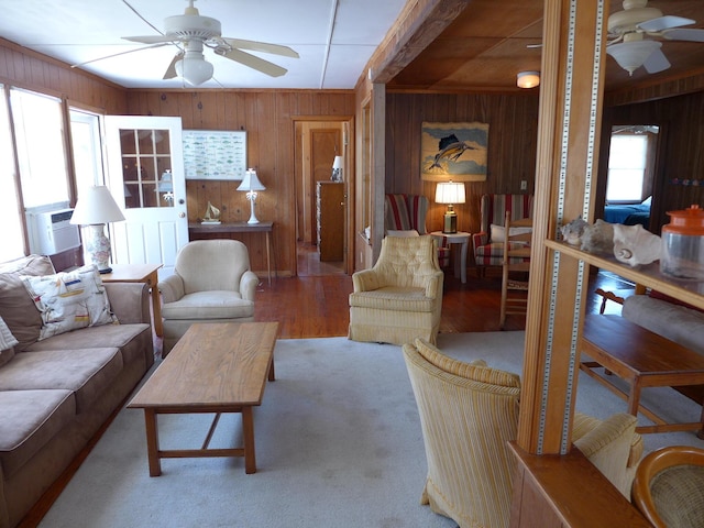 living room featuring wooden walls, ceiling fan, cooling unit, and wood finished floors