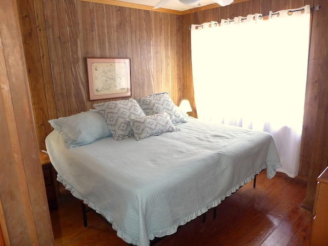 bedroom with wooden walls and hardwood / wood-style floors