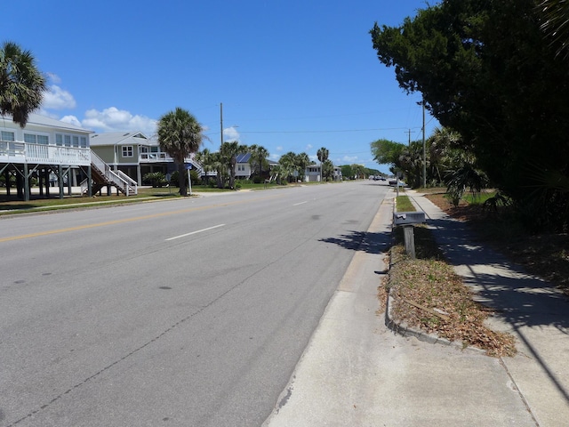 view of street with a residential view, stairs, and curbs