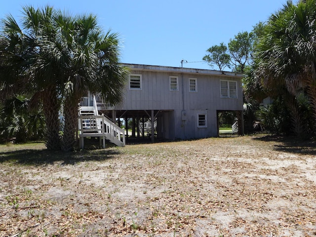 rear view of property with stairs and a carport