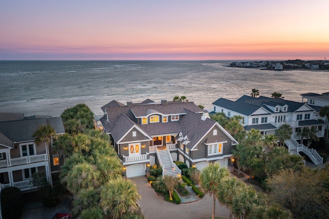 aerial view at dusk featuring a water view