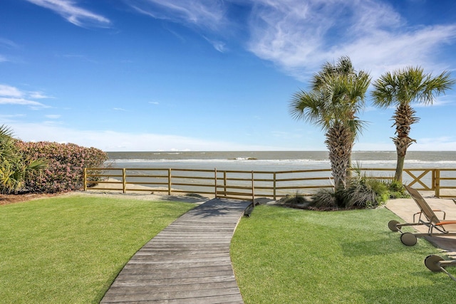 view of yard with a beach view and a water view