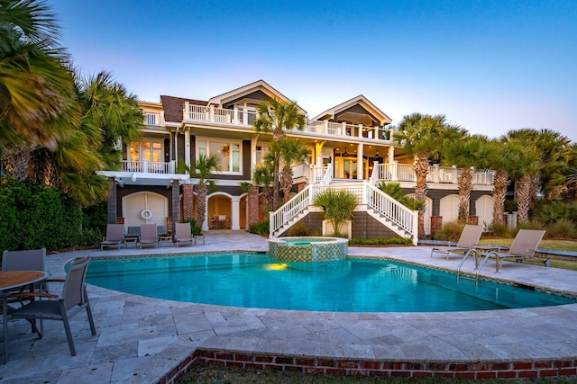 view of swimming pool featuring a patio area and an in ground hot tub