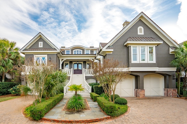 view of front of home with covered porch, a garage, and french doors