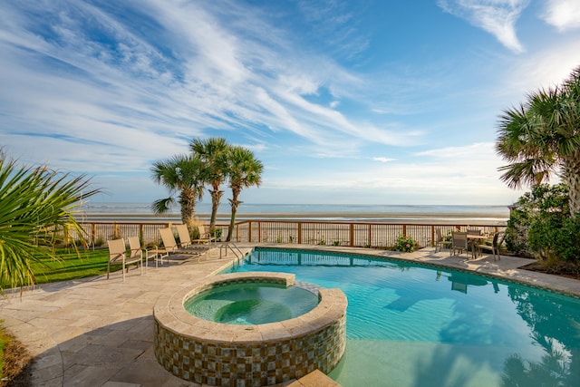 view of pool with a water view, an in ground hot tub, and a patio