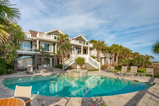 view of swimming pool featuring an in ground hot tub and a patio