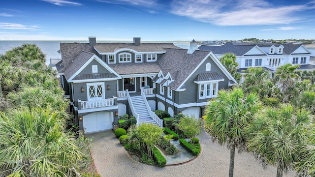 coastal inspired home featuring a garage and a water view