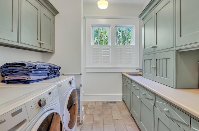 laundry room with washer and dryer, cabinets, light tile patterned floors, and sink