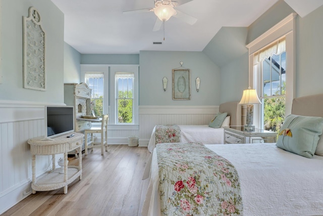 bedroom with ceiling fan, light hardwood / wood-style floors, and lofted ceiling