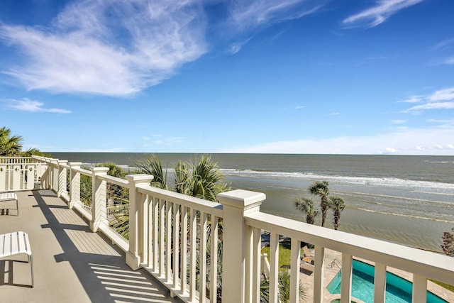 balcony featuring a water view and a view of the beach