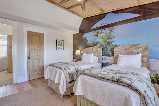 bedroom featuring ceiling fan, light hardwood / wood-style floors, and lofted ceiling