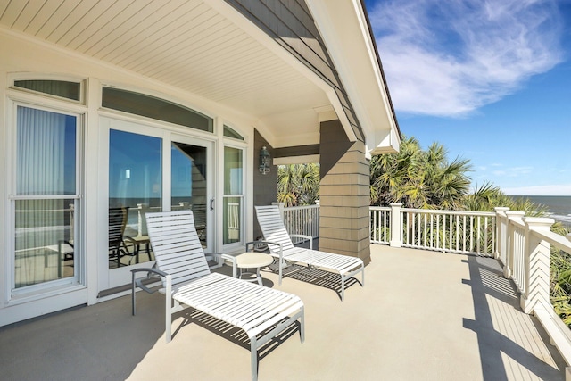 view of patio with covered porch and a water view