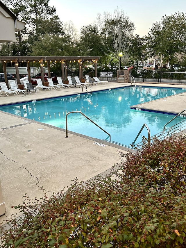 community pool with fence and a patio area