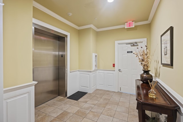 interior space with a wainscoted wall, elevator, ornamental molding, and light tile patterned flooring