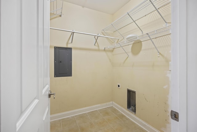 laundry area featuring baseboards, electric panel, laundry area, tile patterned floors, and hookup for an electric dryer