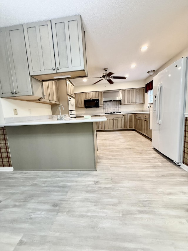 209 Myrtlewood Dr, Santee, SC 29142 - kitchen with white refrigerator with ice dispenser, black microwave, wall chimney exhaust hood, a peninsula, and ceiling fan