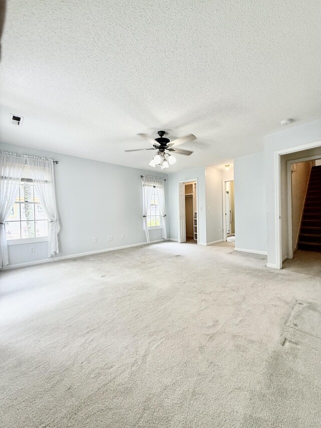 209 Myrtlewood Dr, Santee, SC 29142 - empty room with light colored carpet, healthy amount of natural light, a textured ceiling, ceiling fan, and stairs