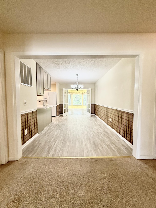 209 Myrtlewood Dr, Santee, SC 29142 - unfurnished living room with a chandelier, wainscoting, carpet, and wood finished floors
