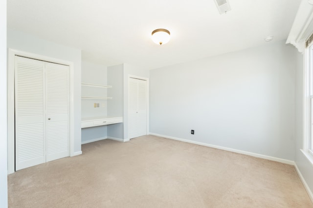 unfurnished bedroom featuring light carpet