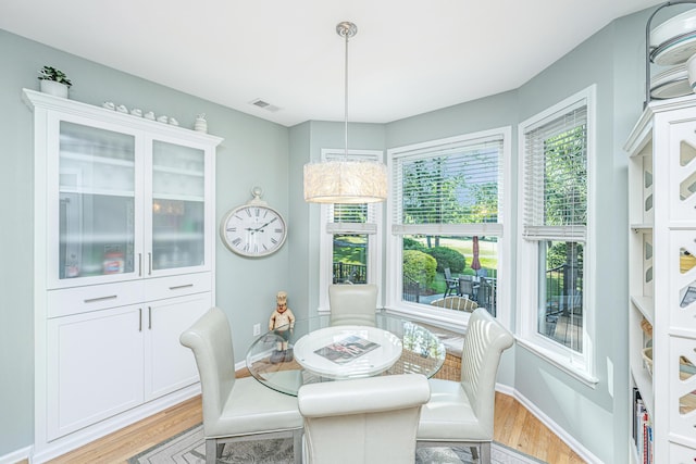 dining area with visible vents, light wood finished floors, and baseboards
