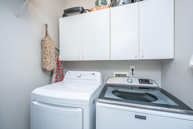 clothes washing area with cabinet space and washer and dryer