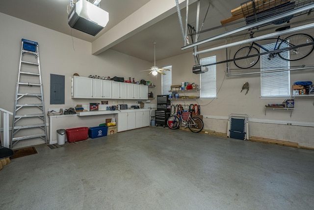 garage with a ceiling fan, a garage door opener, and electric panel