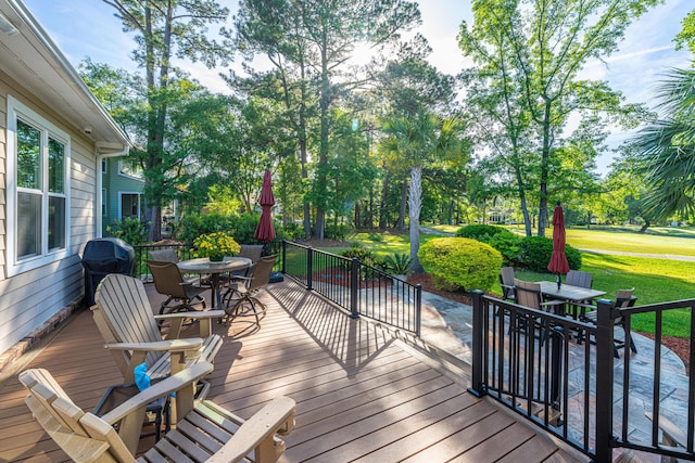 deck featuring a yard and outdoor dining area