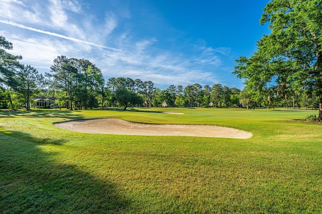 surrounding community with view of golf course and a yard