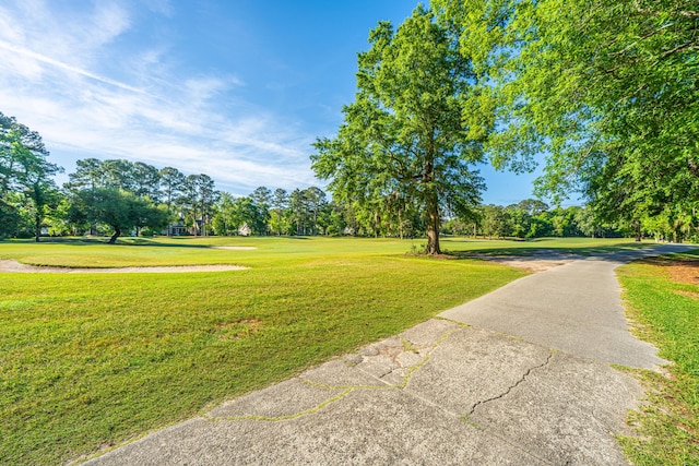 surrounding community with a yard and view of golf course
