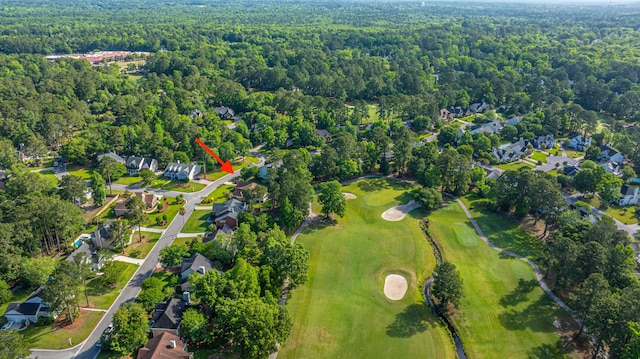 drone / aerial view with a view of trees, golf course view, and a residential view