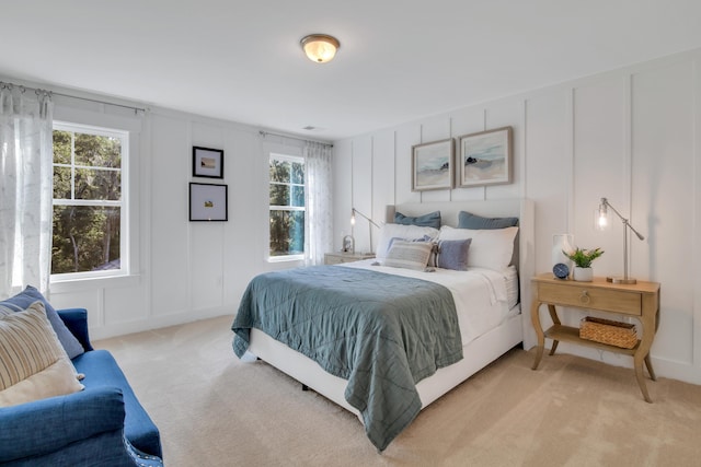 bedroom featuring light carpet and multiple windows