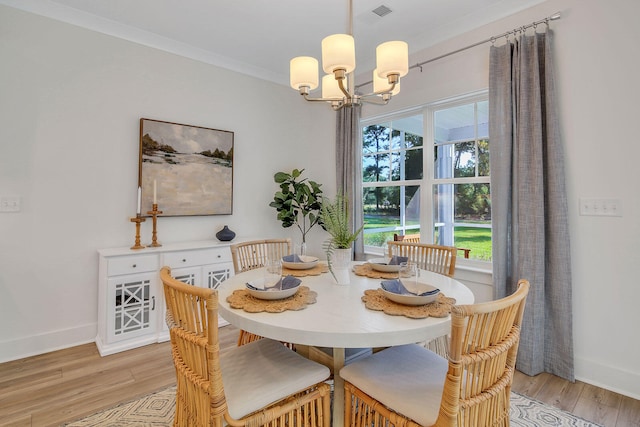 dining area featuring a chandelier, light hardwood / wood-style floors, and ornamental molding