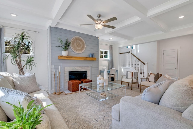 living room with beam ceiling, ceiling fan, and coffered ceiling