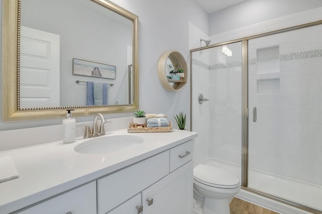 bathroom featuring hardwood / wood-style flooring, toilet, and a shower with door