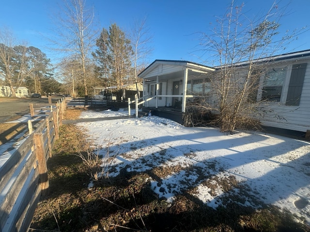 snow covered property featuring covered porch