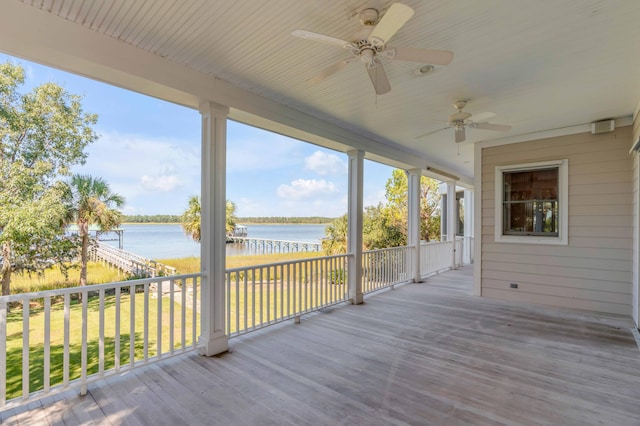 deck with a water view, a yard, and ceiling fan