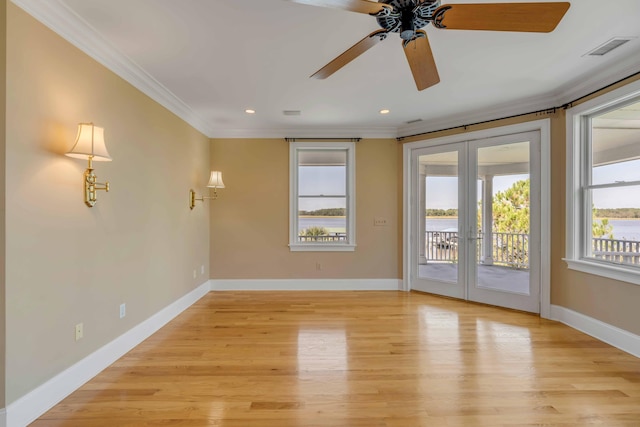 spare room featuring ceiling fan, light hardwood / wood-style flooring, crown molding, and french doors