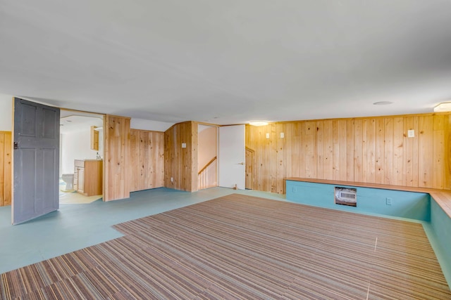 unfurnished room featuring wooden walls